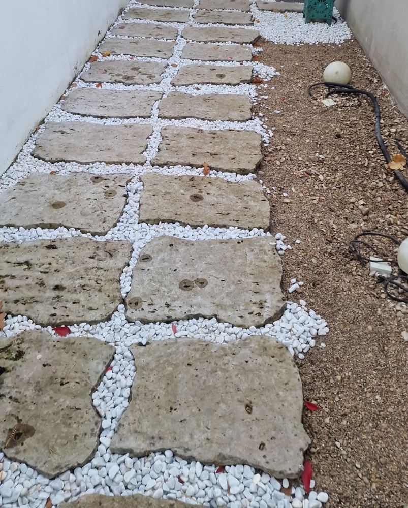 Gepflegter Innenhof mit Trittplatten und weißem Kies
